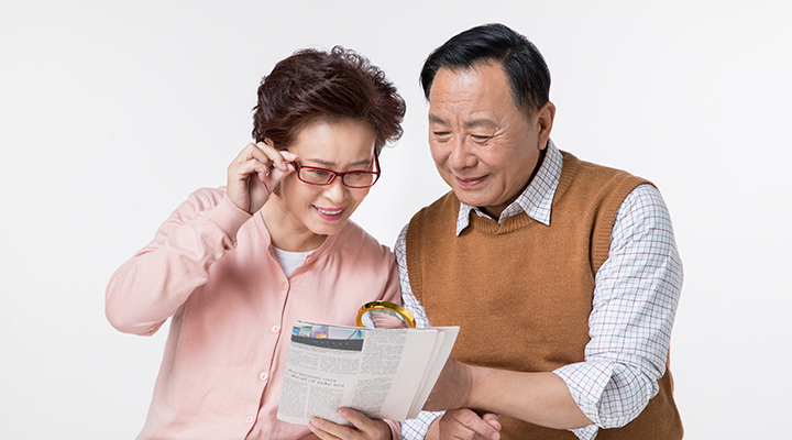 신문을 함께 보며 안경을 사용하는 60대 이상 부부